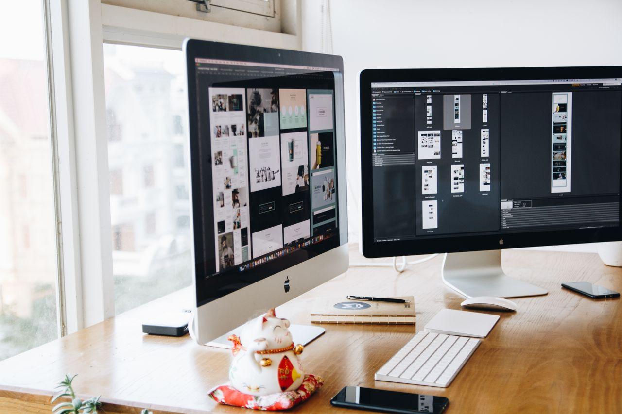 Service A sleek modern office setup featuring dual monitors, Apple devices, and creative decor in an indoor workspace.